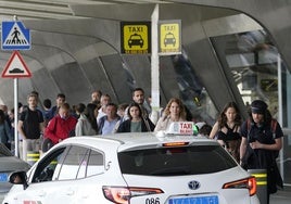 Imagen de archivo en el que varias personas hacen cola para coger un taxi en el aeropuerto.