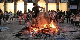 Un joven salta encima del fuego en la hoguera de San Juan de la plaza de San Nicolás de Algorta.