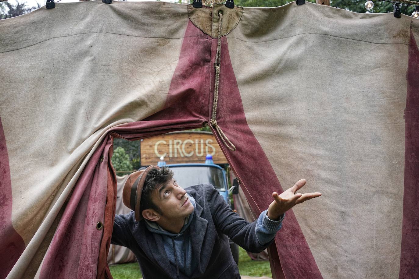Un artista de la compañía catalana Pau Palaus mira al cielo lluvioso en la entrada a la carpa de su circo, donde se desarrolla el espectáculo 'Zotly'.