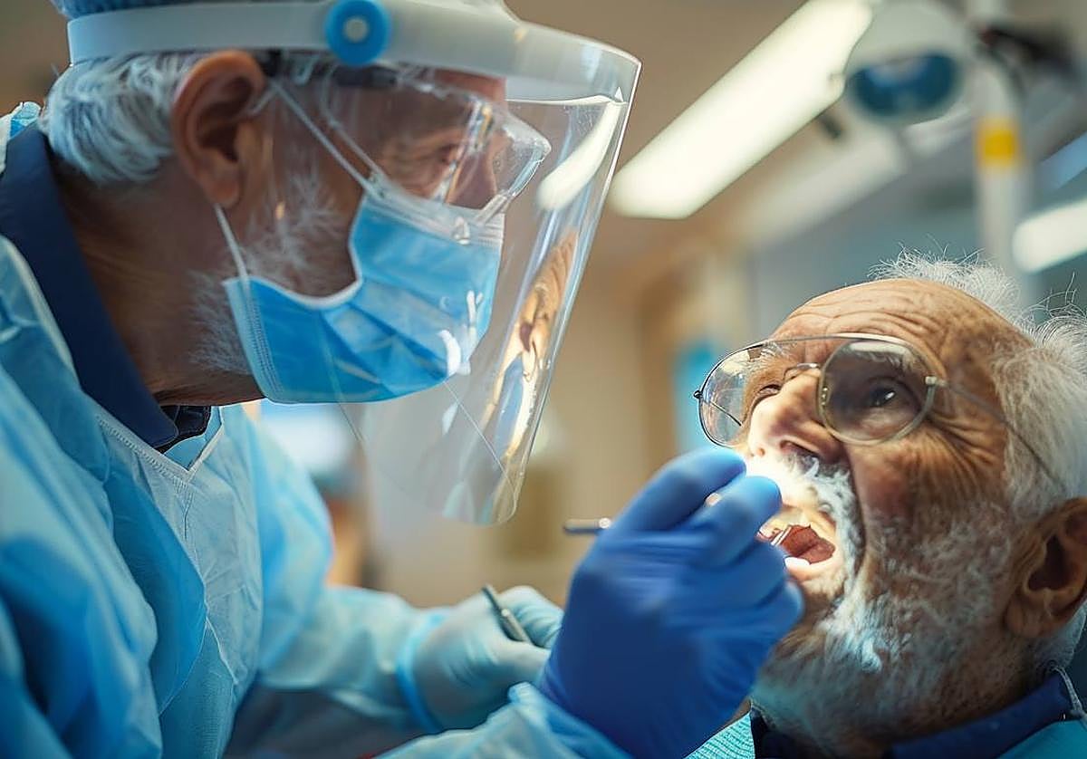 Un odontólogo explora la boca de un paciente en busca de piezas dentales dañadas y de posibles tumores.