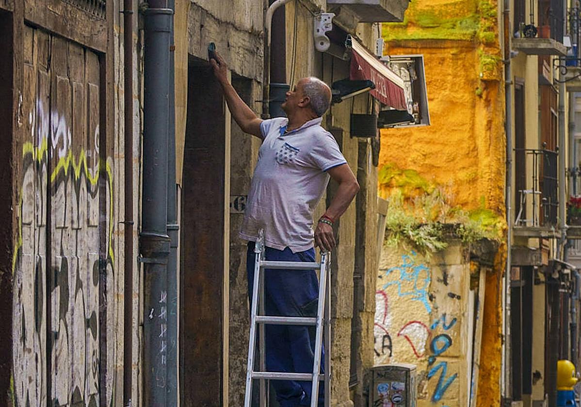 Un operario trabaja en un nuevo negocio en la calle Herrería.