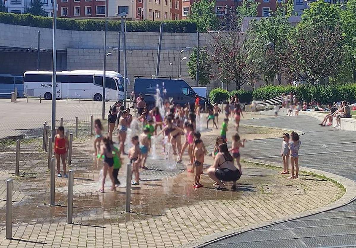 Varios niños se refrescan este viernes en los chorros de agua del Guggenheim Bilbao.