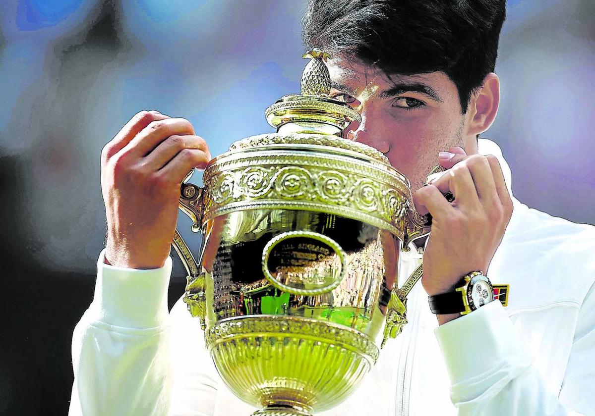 Alcaraz besa el trofeo después de ganar a Djokovic en tres sets en la final de Wimbledon.