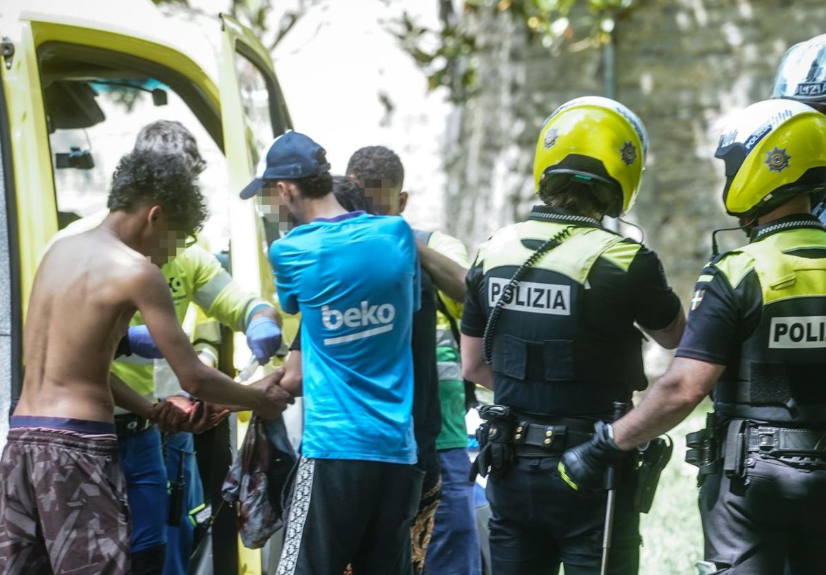 Sanitarios atienden al herido, ante varios policías locales.