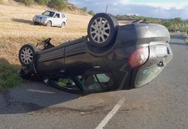 El coche volcado en la carretera.