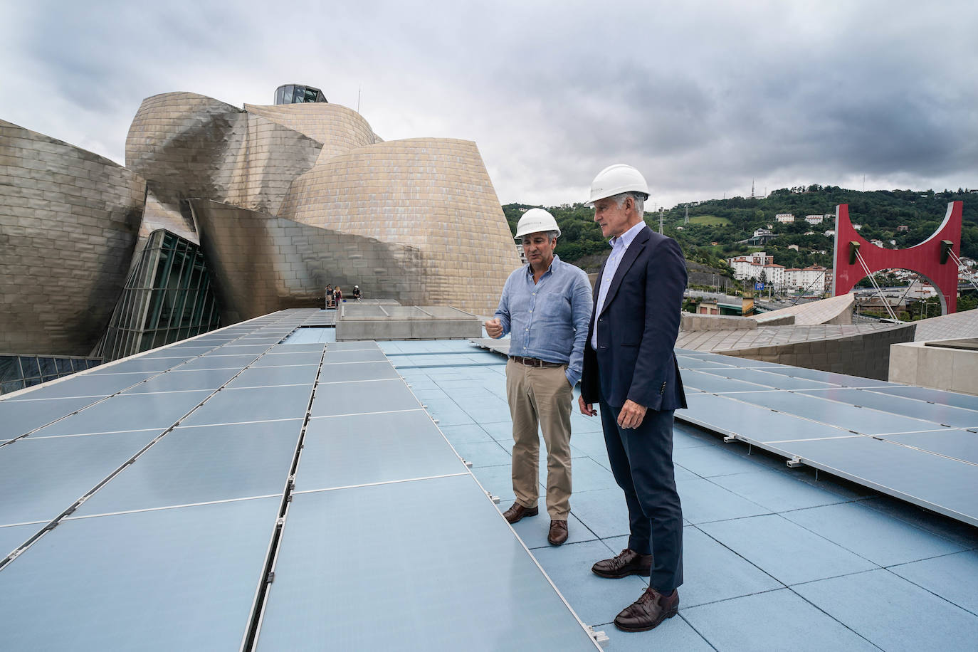 Juan Ignacio Vidarte y Rogelio Diez visitan una de las azoteas donde se han instalado los paneles de color azul.