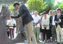 El alcalde de San Sebastián, Eneko Goia, colocando unas flores en el monumento a las víctimas.