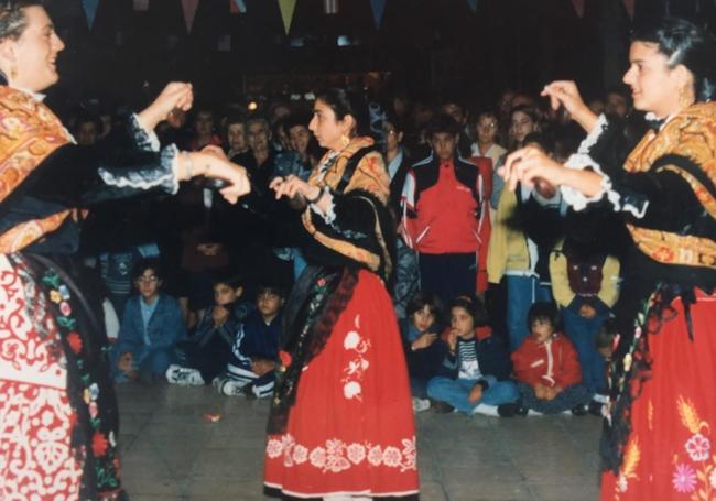 El grupo de baile del Hogar extremeño durante un acto en una imagen antigua.