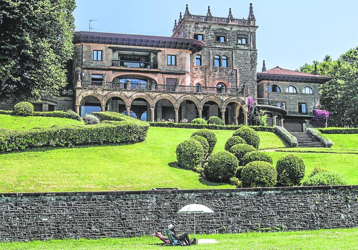 Una persona toma el sol junto a los jardines del palacete getxotarra.