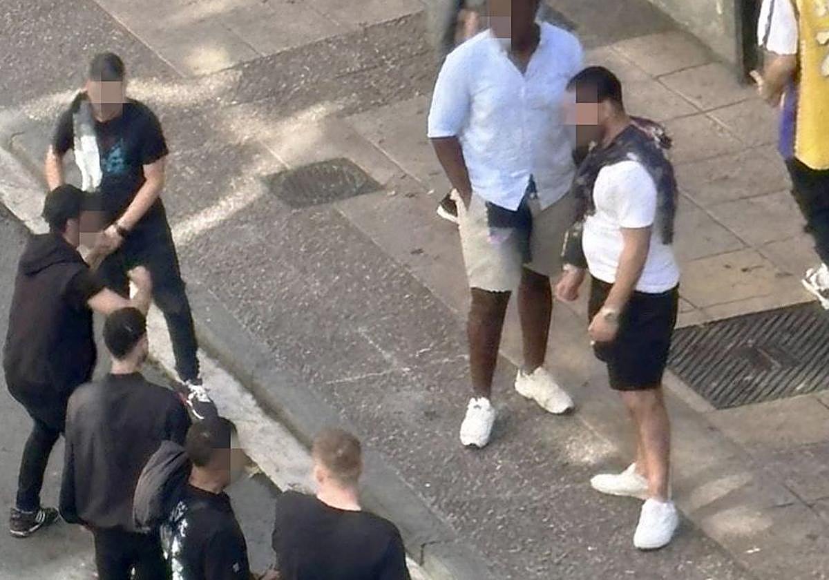 El joven identificado, a la izquierda y con gorra y vestimenta negra, antes de ir a la calle Postas.