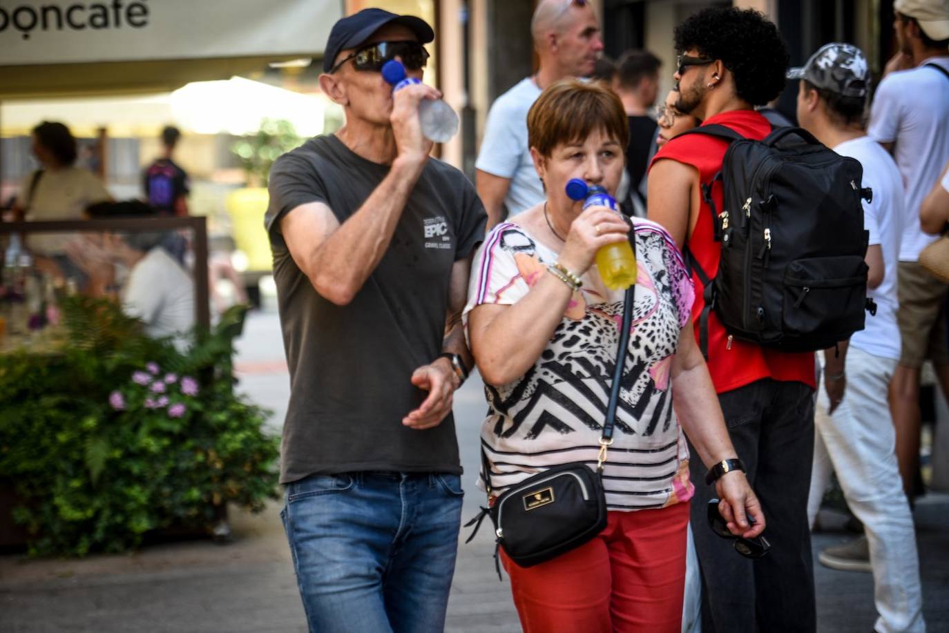 La gente se hidrata con refrescos mientras pasea por las calles de la villa