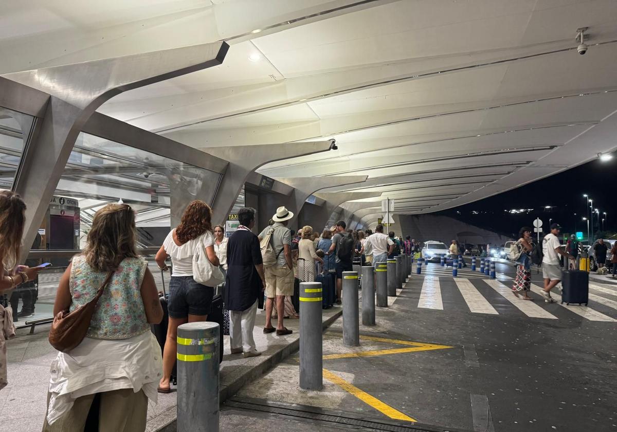 Varias decenas de personas esperan un taxi el sábado por la noche en el aeropuerto de Loiu.