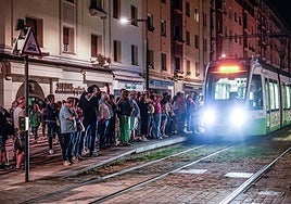 Numerosos ciudadanos aguardan la llegada del tranvía durante una de las noches de fiestas de Vitoria.