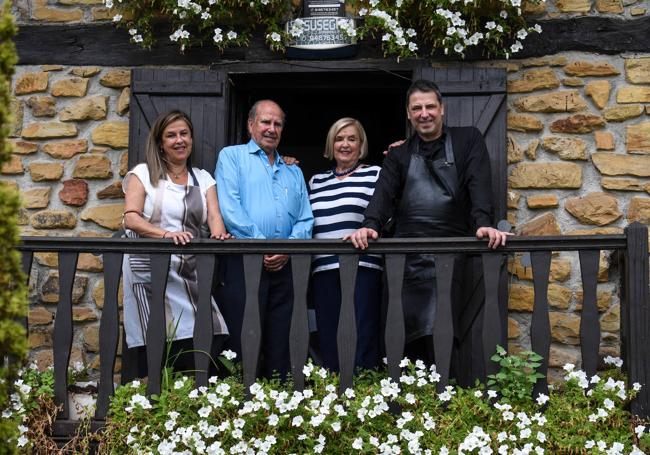 Iratxe y Jon Andoni flanquean a sus padres, Rosa María Echeandía (76) y Juan Antonio Rementería (84), en el balcón del caserío, siempre engalanado con flores; este verano, surfinias blancas.