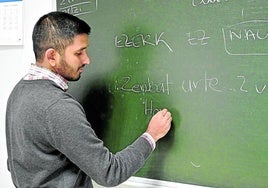 Un estudiante de euskera escribe en una pizarra del barnetegi de Lazkao.