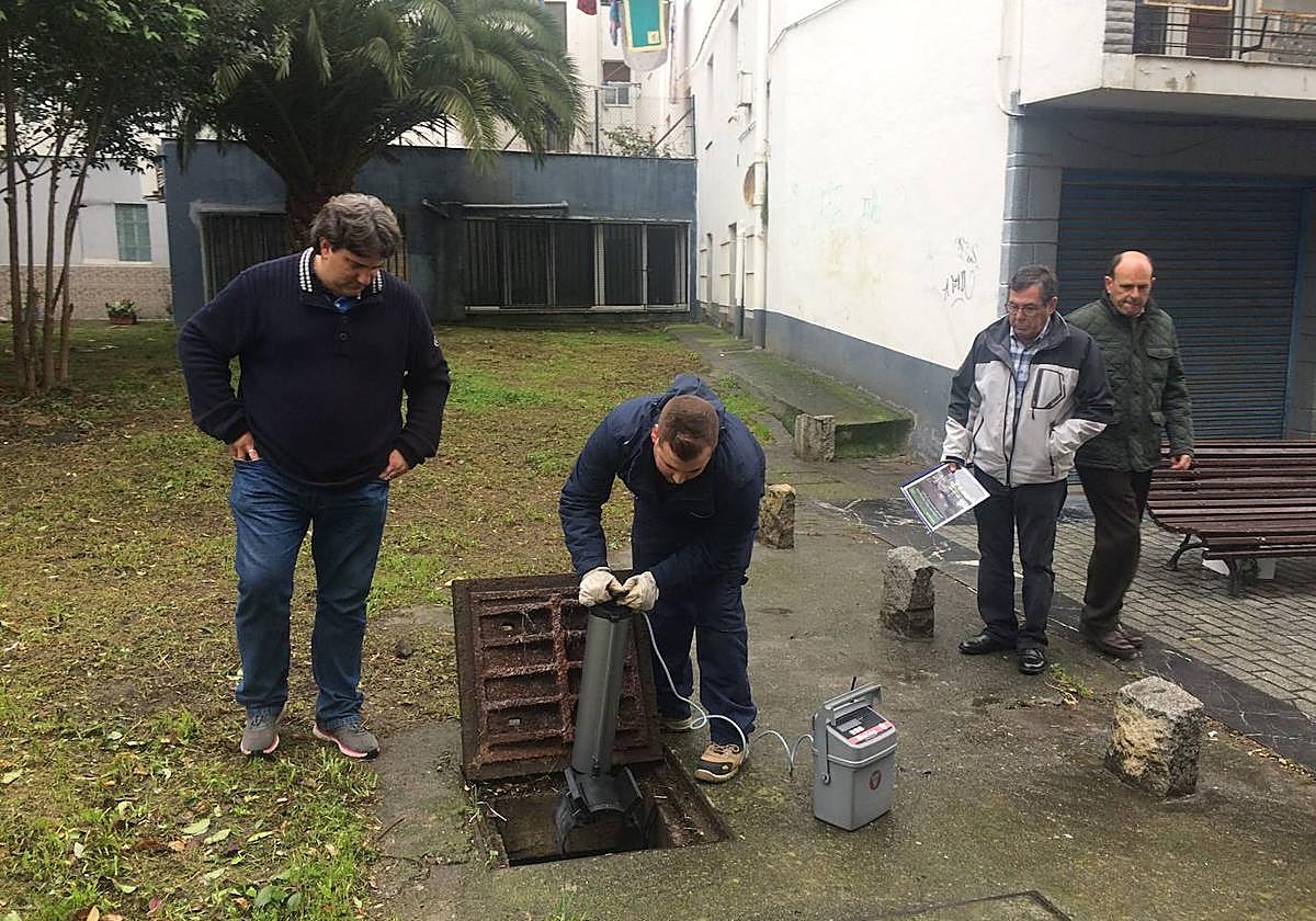 Un operario introduce una trampa para ratas en una arqueta.