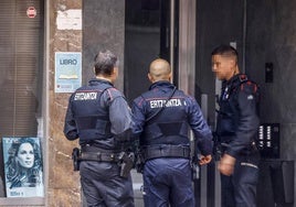 Agentes de la Ertzaintza aguardan en el portal del edificio de viviendas de la calle Cuba, en el barrio de El Pilar, donde se produjo el apuñalamiento.