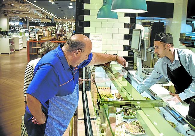 Un cliente elige su comida en la sección de platos preparados de El Corte Inglés de Bilbao.