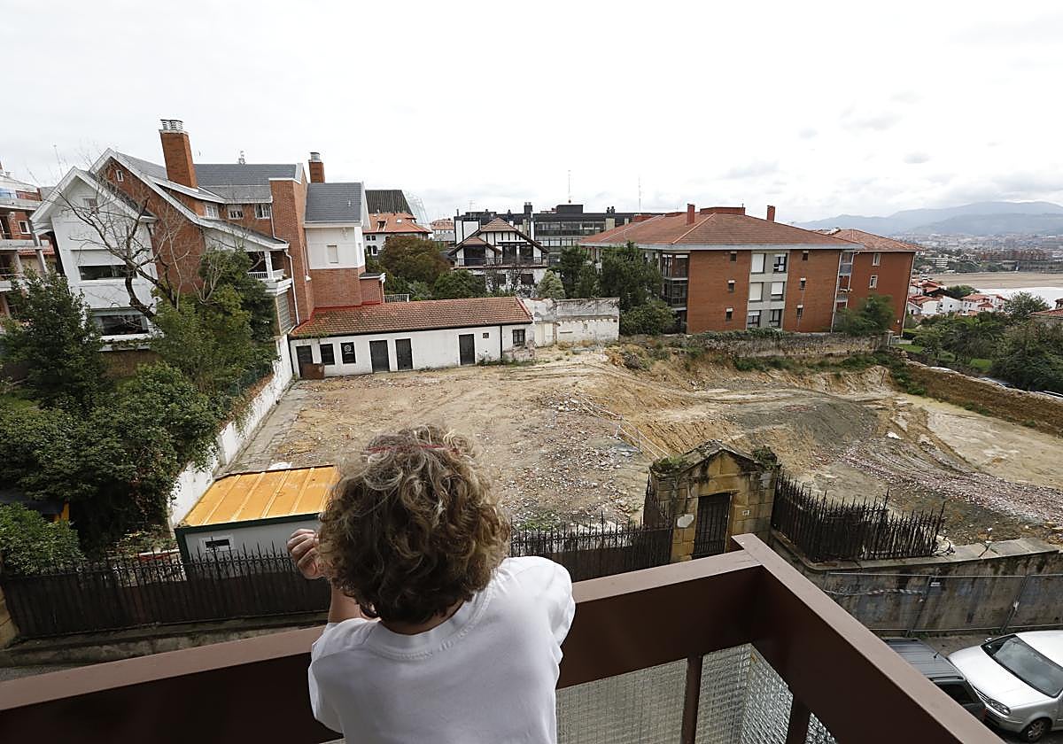 Una vecina contempla cómo ha quedado el solar en el que se derrbó un palacete para construir pisos de lujo.