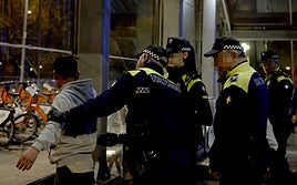 Agentes de la Policía Municipal de Getxo cachean a un joven en el acceso a la estación del metro en Algorta durante los carnavales.