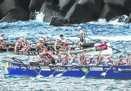 La tripulación de Urdaibai celebra la victoria ante su público con la trainera de Zierbena al fondo.