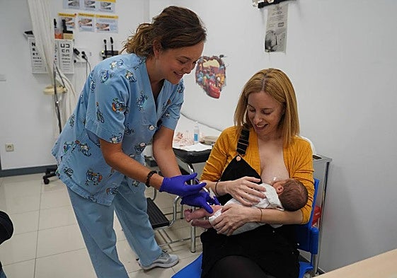 La enfermera Ana Belén Pereiro administra la vacuna contra la bronquiolitis a la pequeña Leize, en brazos de su ama Eider González.