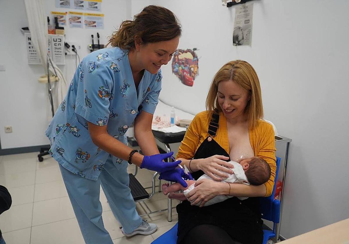 La enfermera Ana Belén Pereiro administra la vacuna contra la bronquiolitis a la pequeña Leize, en brazos de su ama Eider González.