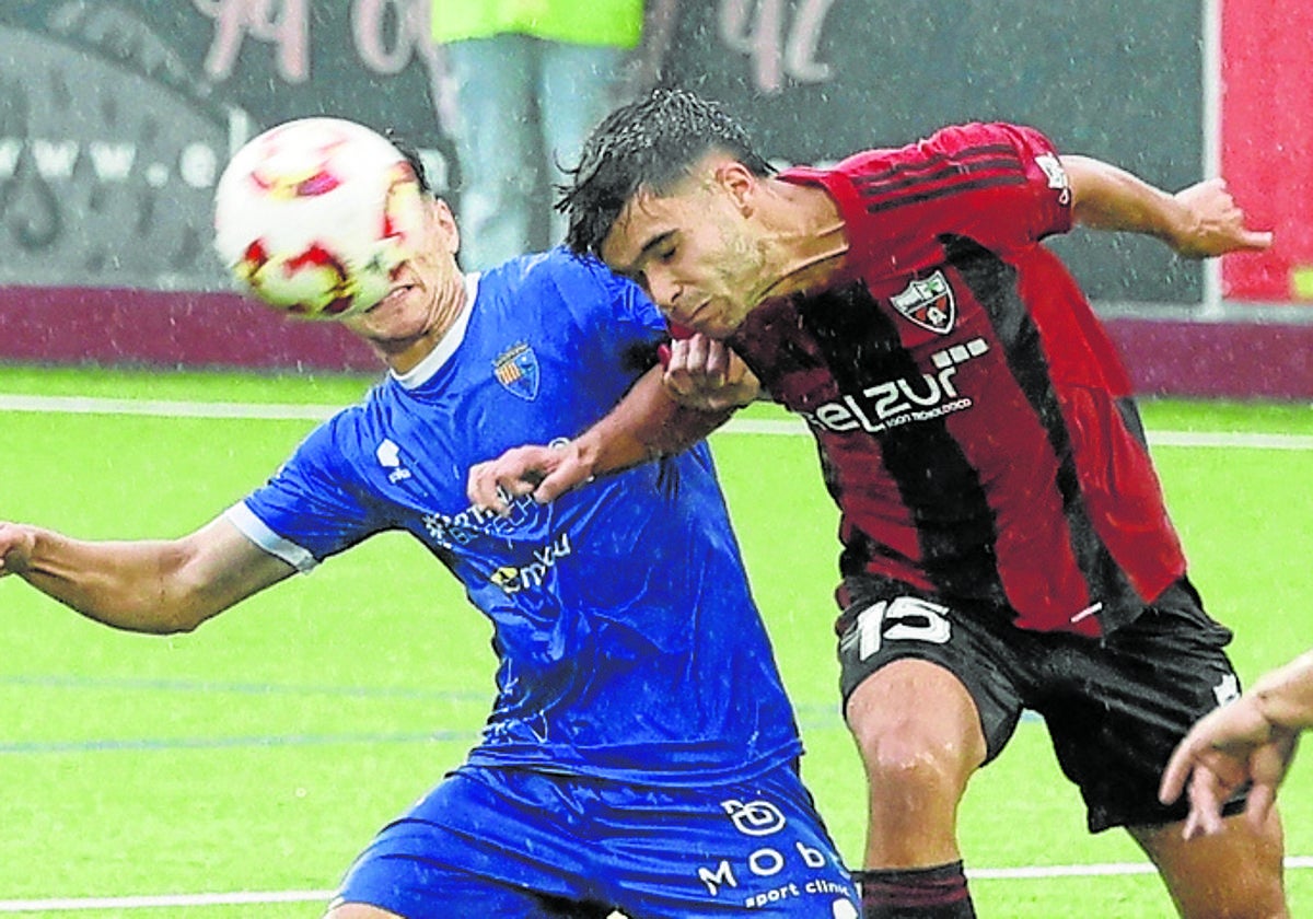 Un jugador del Arenas despeja un balón de cabeza.