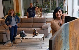 Los tres artistas del proyecto junto a alguna de sus piezas en uno de los locales.