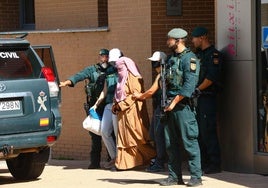 Efectivos de la Guardia Civil trasladan a la sospechosa, vestida con un niqab, tras el registro de su piso en el barrio de Zabalgana.