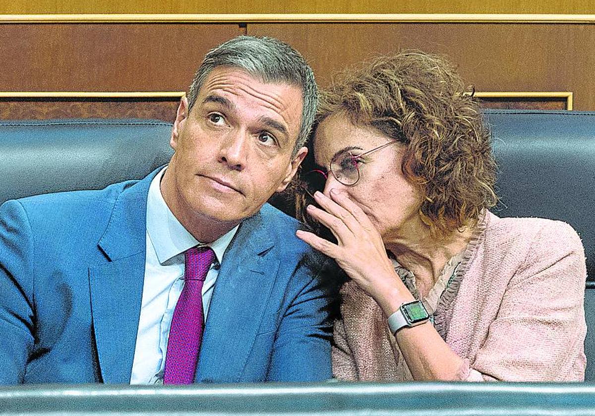 María Jesús Montero comenta una votación con Pedro Sánchez en el Congreso.