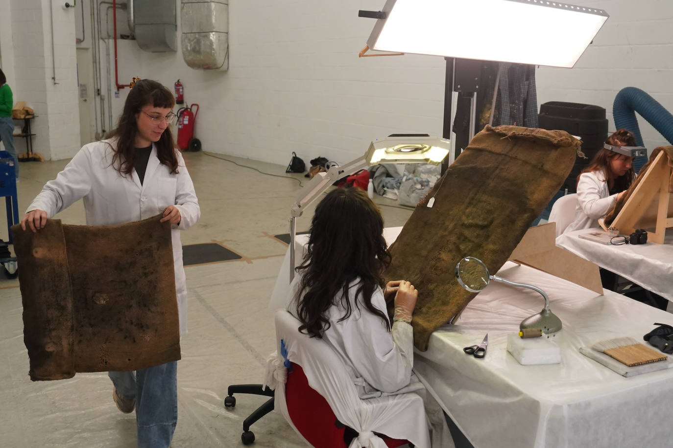 Estudiantes de la UPV/EHU cosen los sacos de la obra de Kounellis.