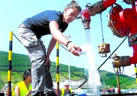 Una técnico toma una muestra de agua para analizarla en el transporte de agua a Urdaibai en buque cisterna.