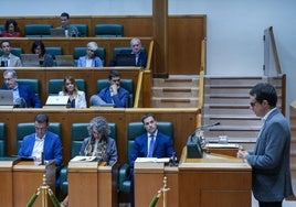 Pello Otxandiano habla desde la tribuna bajo la mirada de Imanol Pradales, este viernes en el Parlamento vasco.