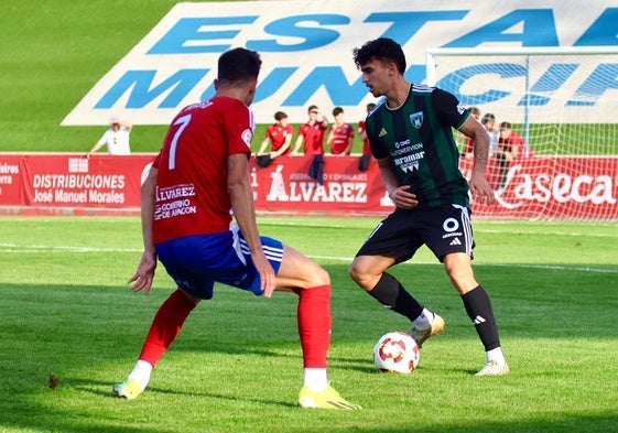 Adrián Miranda conduce el balón ante Javi Areso.