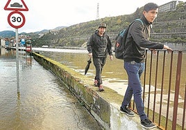 Dos personas caminan por el muro que separa Zorrozaurre de la ría para evitar la zona que cubrió las mareas vivas.