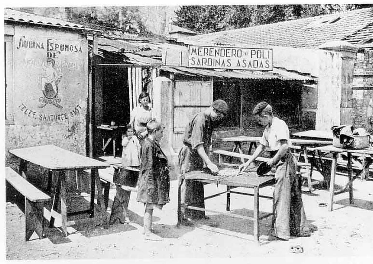 Imagen secundaria 1 - Arriba, dibujo sin datar que recrea las construcciones junto al puerto. A la izquierda, imagen del merendero Poli, famoso por sus sardinas, en 1918. A la derecha, la alcaldesa, Karmele Tubilla, y la edil de Cultura, Itziar Carrocera, junto a Gorka Bóveda (izquierda) y Carlos Morán, del equipo motor del 950, muestran su pin con el logo de la efeméride.