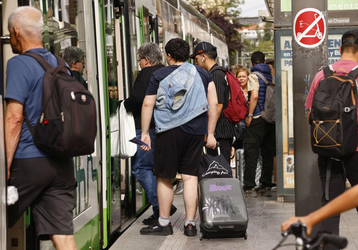 Varios ciudadanos suben al tranvía en Vitoria.