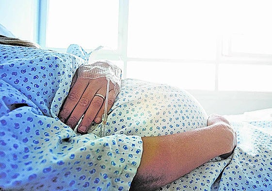 Una mujer embarazada en la cama de un hospital antes de dar a luz.