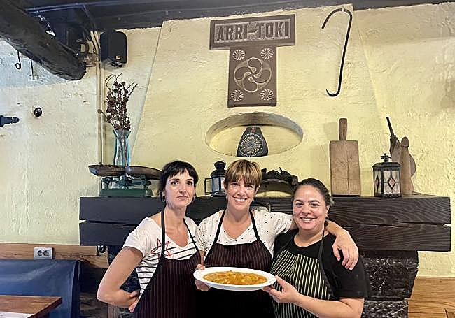 Elisa Vega, en el centro, sostiene una ración de callos y morros junto a Arantxi Maiztegi y Judith Cabreja, con quienes trabaja codo con codo en la cocina y en el servicio.