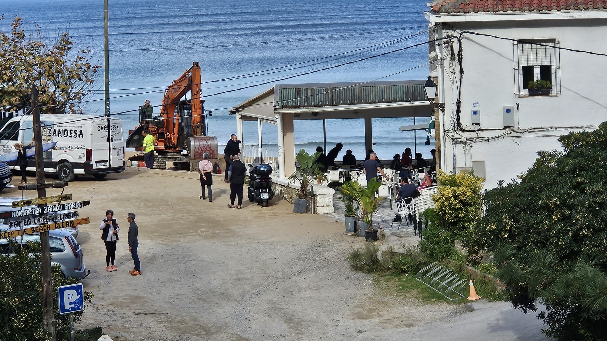 Operarios tratan de poner en marcha la máquina que ha quedado paralizada y en cuya pala se puede leer 'Itxi Laga bakean'.