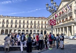 Un grupo de turistas escuchan las explicaciones en la plaza de España.