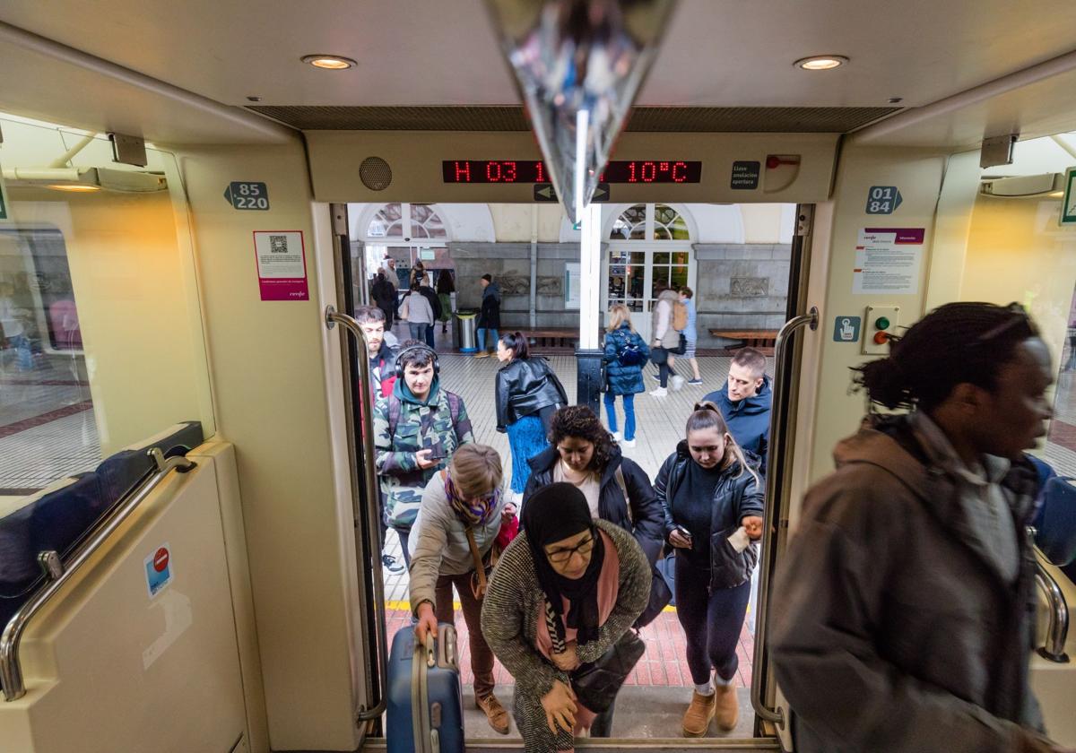 Varios pasajeros se suben al tren en la estación de Dato.