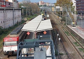 Varios pasajeros al fondo subiendo por la pasarela provisional tras abandonar un tren con destino Muskiz en la estación baracaldesa.