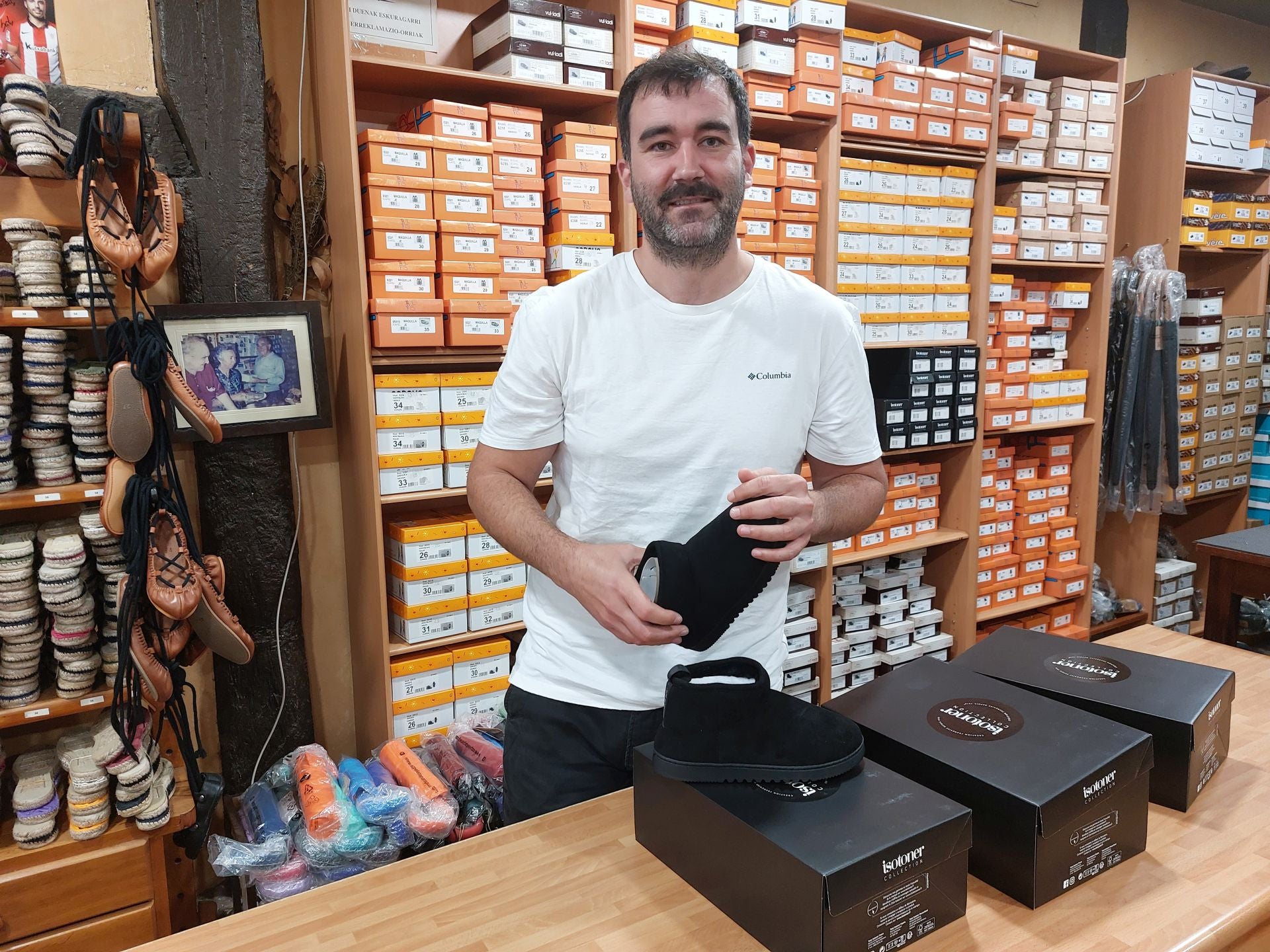 El joven Txaber Arrilaga muestra las zapatillas de su comercio Sillero.