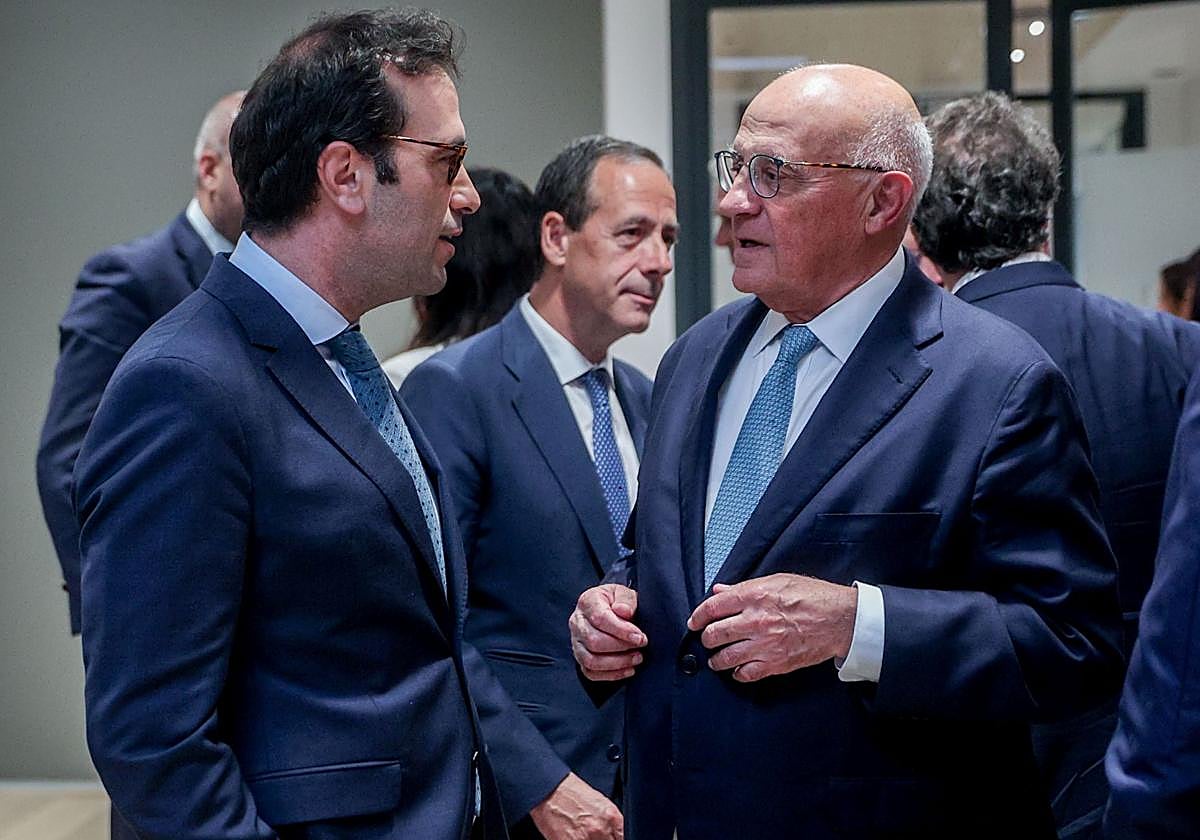 El ministro de Economía, Carlos Cuerpo, charla con el presidente del Sabadell, Josep Oliu.
