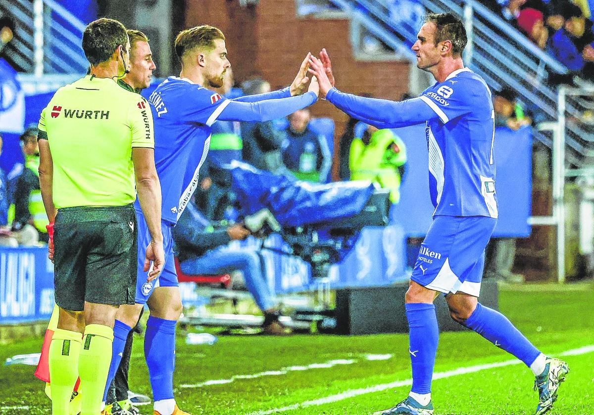 Kike García choca las manos con Toni Martínez, que se dispone a ingresar al terreno de juego en su lugar.