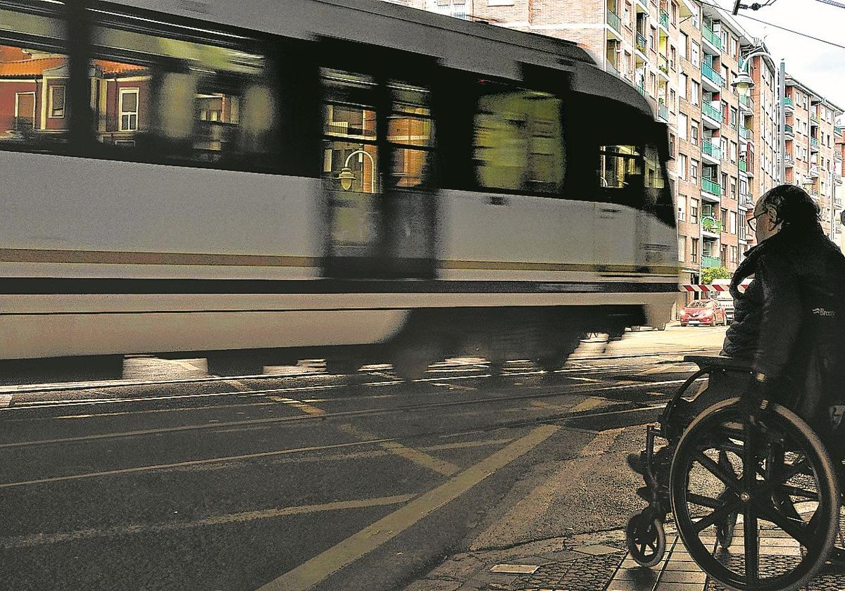 Una persona en silla de ruedas espera el paso del tren en el punto conflictivo