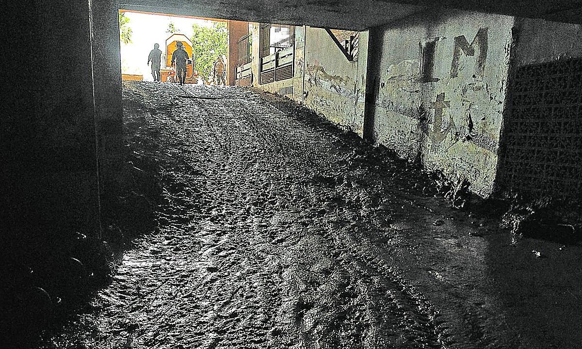 En Catarroja. Un grupo de militares trabaja en la limpieza de un garaje anegado de barro por la dana.