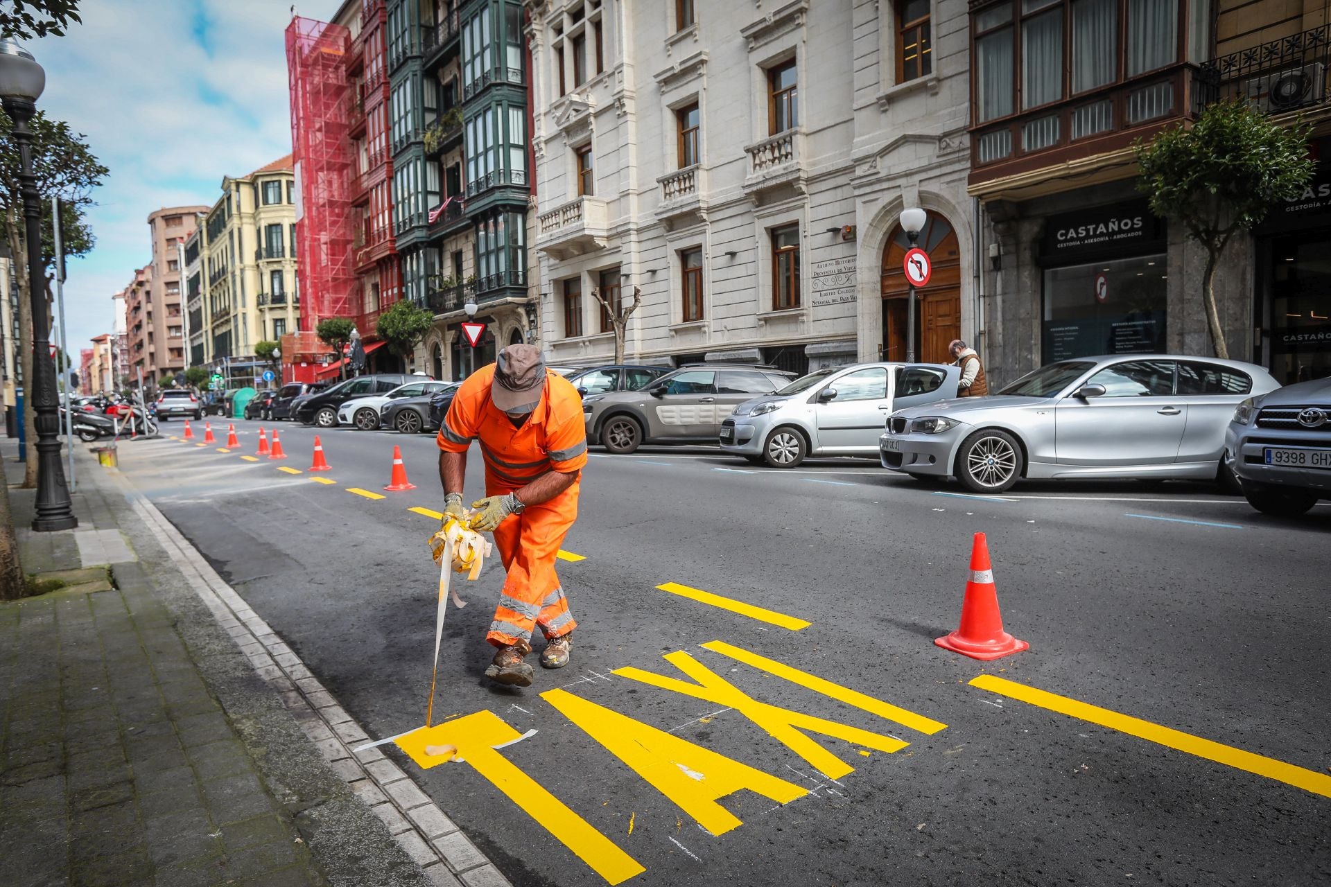 Un operario pinta una parada de taxis en una calle de Bilbao.